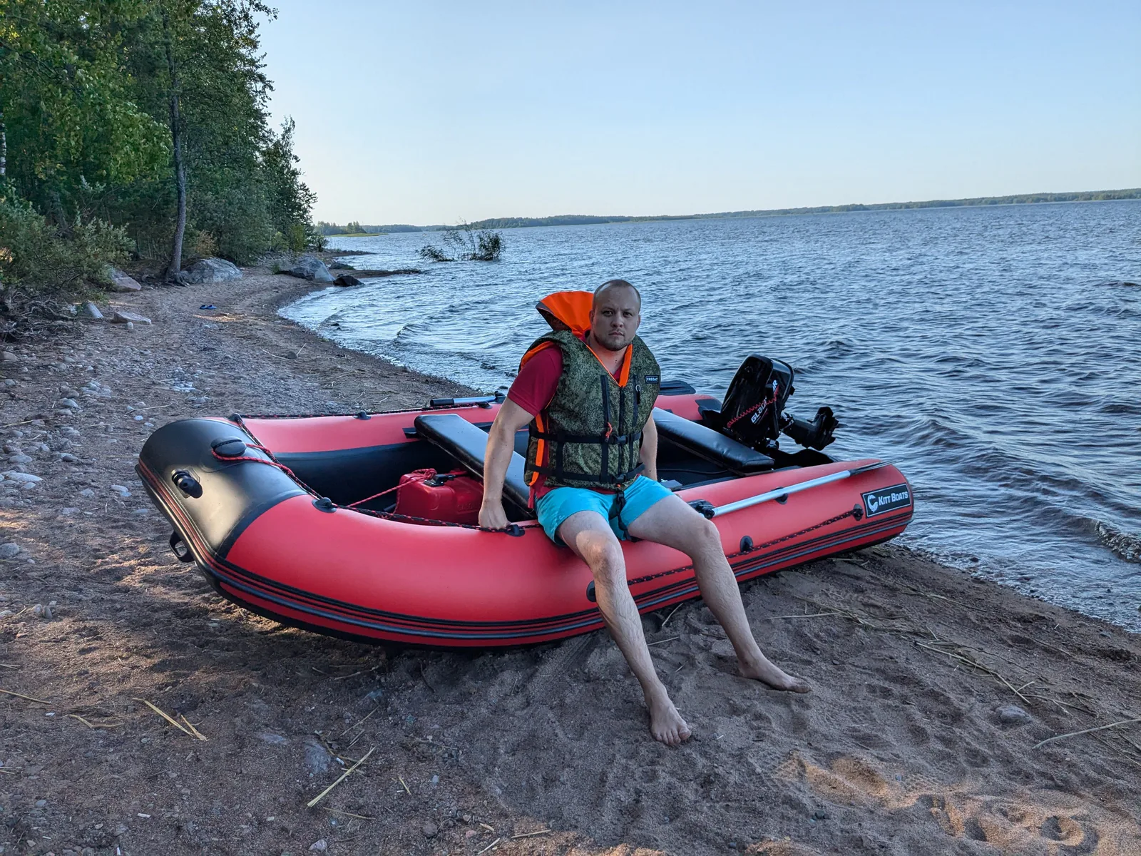 Двое владельцев отдыхают в красной лодке KITT BOATS на каменистом берегу