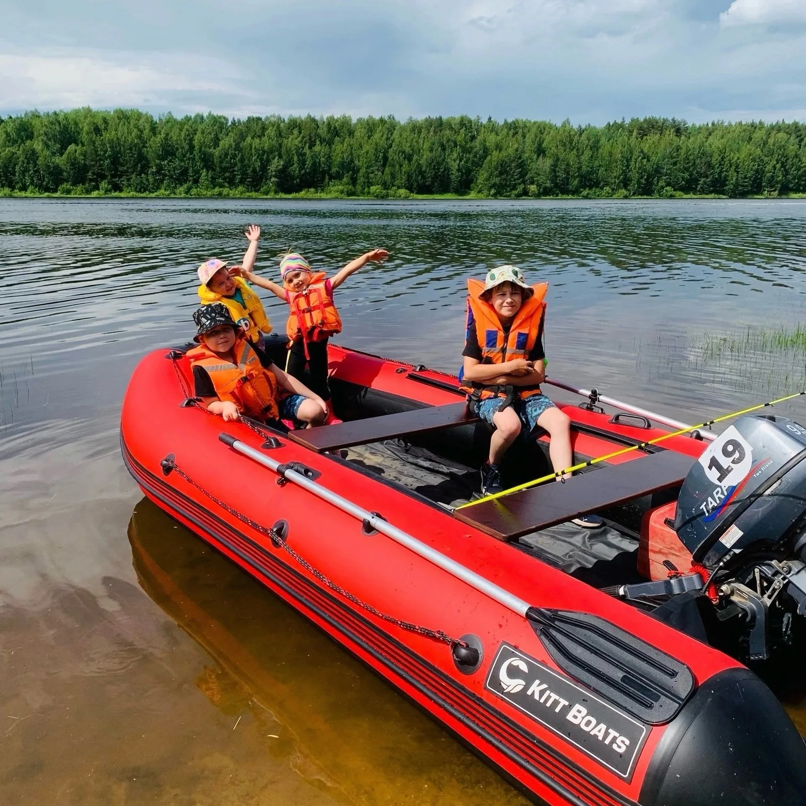 Семья в спасательных жилетах отдыхает в красной лодке KITT BOATS